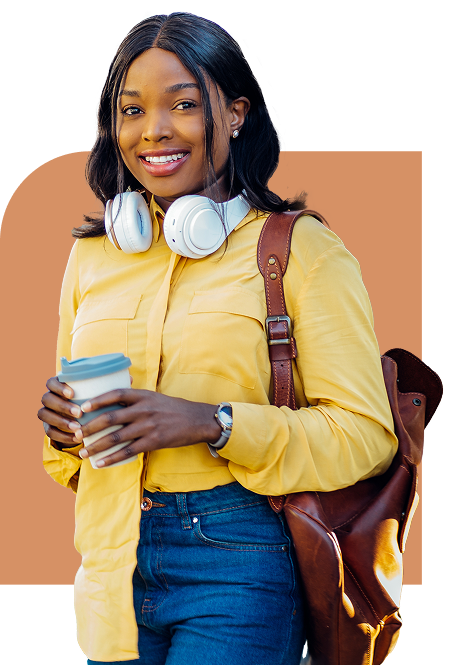 Smiling young woman holding a coffee cup with headphones around her neck and a backpack on her shoulder