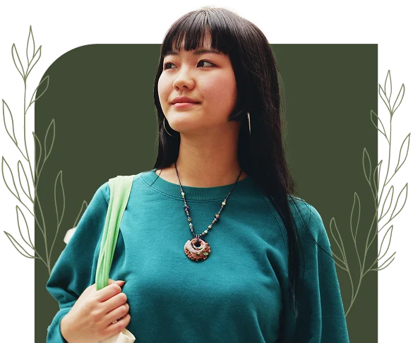 Young woman looking upward with a calm expression while carrying a tote bag in front of a decorative background
